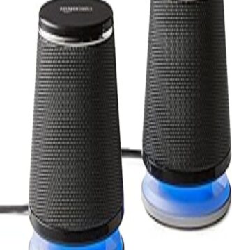 The image shows a compact set of Amazon Basics stereo speakers designed to enhance audio experiences. The two black rectangular speakers are positioned side by side. Each speaker features a sleek and minimalist design with a fine mesh grille on the front and the Amazon Basics logo subtly