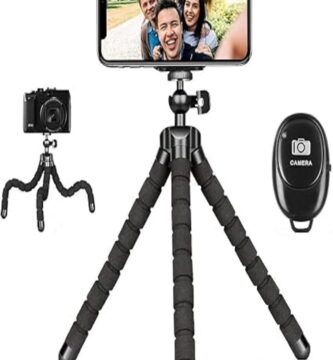 The image showcases a KAMISAFE Flexible Tripod positioned outdoors on a rocky surface. The tripod is small and lightweight with bendable, octopus-style legs, allowing it to grip onto uneven surfaces securely. A smartphone is mounted on the tripod,