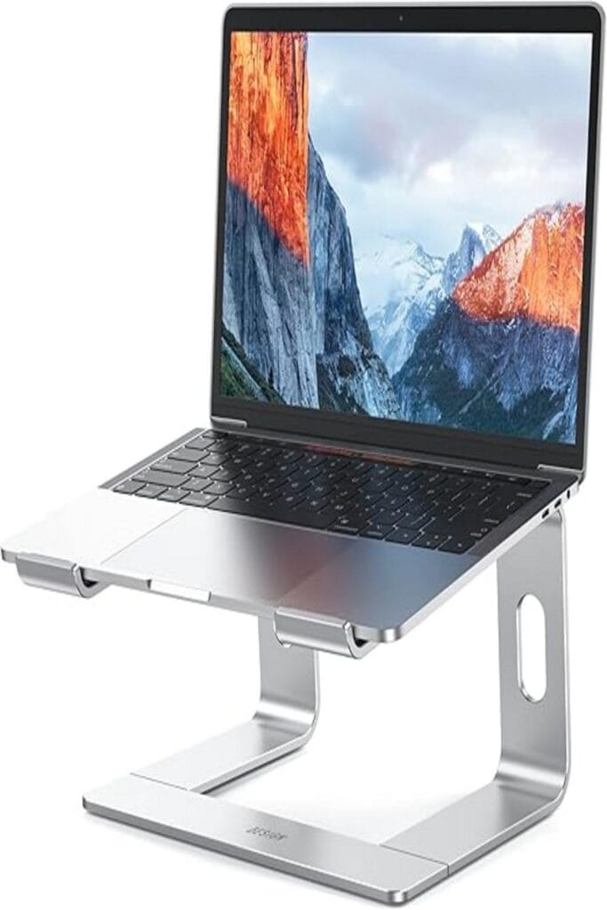 The image features the Besign LS03 Laptop Stand, elevating a laptop to eye level. The stand is constructed from sleek, silver aluminum and has a minimalist design that complements modern workspaces. It is adjustable for various viewing angles and promotes ergonomic posture