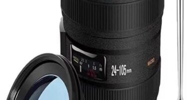 Camera lens-shaped coffee mug on a table, perfect for photography enthusiasts.