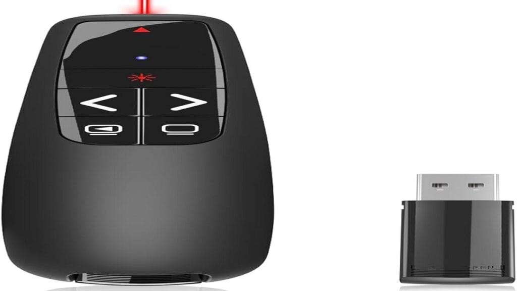 A sleek presentation clicker beside a laptop on a wooden desk.