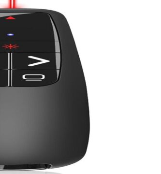 A sleek presentation clicker beside a laptop on a wooden desk.